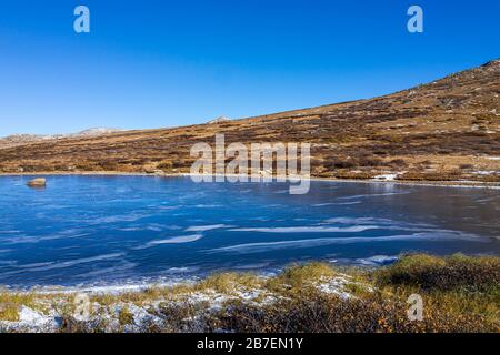 Independence Pass in autumn on highway 82 rocky mountain continental divide in Colorado with winter snow and frozen surface of lake Stock Photo