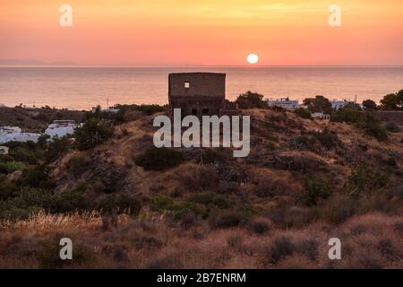 A gradual & splendid sunrise.Sunlight shines through the window of a shanty   ruin, highlighting a tuft of hillside. This is the Alboran Sea of Southe Stock Photo