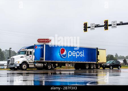 Chetopa, USA - October 15, 2019: Rainy street road in small town in Kansas countryside with blue pepsi truck by Conoco gas station Stock Photo