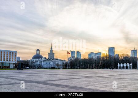 Warsaw, Poland - December 19, 2019: Downtown modern cityscape skyline with red Polish flag waving by Palace of Culture and Sciences building and Holy Stock Photo