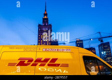 Warsaw, Poland - December 19, 2019: Downtown modern cityscape with Palace of Culture and Sciences building skyscraper and yellow DHL express delivery Stock Photo
