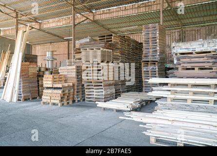 Pile of pine wood in a warehouse or storage room. Wood proceesing, wood for furniture Stock Photo