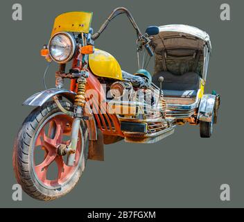 Old motocycle converted to a tricycle moto rickshaw on isolated olive green background with clipping path. Stock Photo