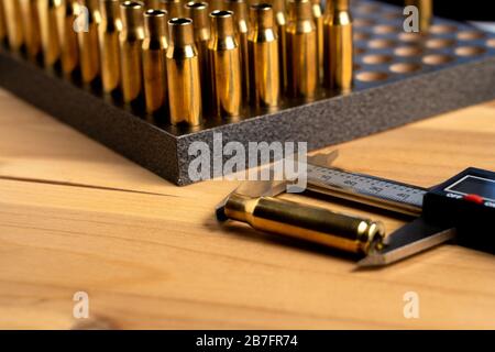 Production of cartridges for a rifle, reload. Measurement of the empty cartridges with a caliper Stock Photo