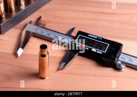 Production of cartridges for a rifle, reload. Measurement of the empty cartridges with a caliper Stock Photo