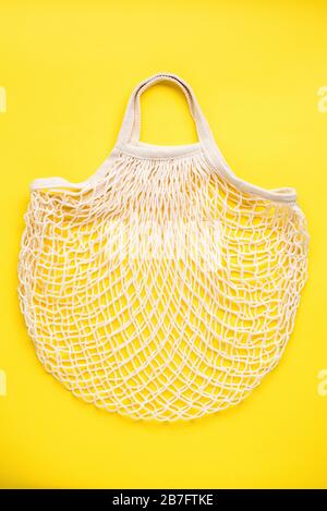 Reusable mesh shopping bag on yellow background. Eco friendly zero waste concept Stock Photo