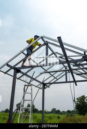 CHONBURI, THAILAND - Oct 12, 2016 Unidentified man walk and work on the steel frame of the house is under construction without protective equipment. Stock Photo