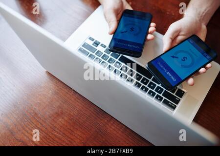 Two business people using mobile application to transfer money from one banking account to another Stock Photo