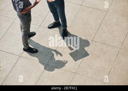 Business people standing outdoors and discussing news and important issues Stock Photo