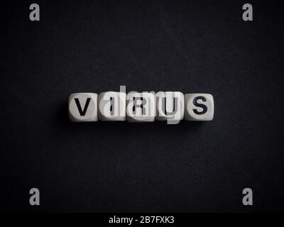 Coronavirus or Covid-19 concept. Wooden cubes text "VIRUS" on dark background. Stock Photo