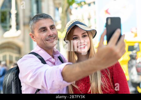 Happy couple making selfies during city visit. Tourism and holiday concept. Stock Photo