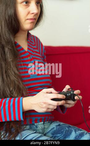 Portrait of young woman playing video games Stock Photo