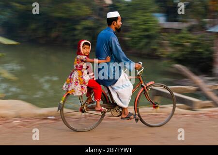 A group of Bangladeshi people traveling by bicycle from the countryside, Bangladesh. Stock Photo