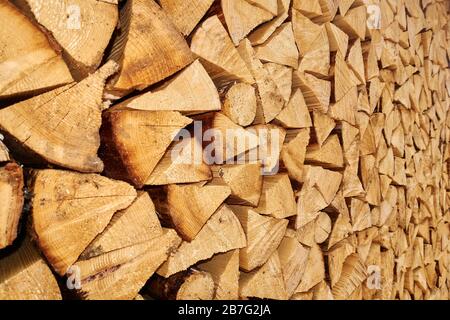 Background image of stacked, dry chopped logs used for firewood. Pile of logs ready to be used in fireplace. Alternative warming method. Stock Photo