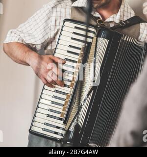 Live music background. Accordionist plays vintage accordion. Close-up square photo Stock Photo