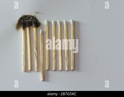 Social distancing concept showing how it can stop spreading of corona virus pandemic. One match with more distance stops burning of others. Stock Photo