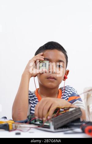Boy holding processor for identify and repairing computer motherboard ...