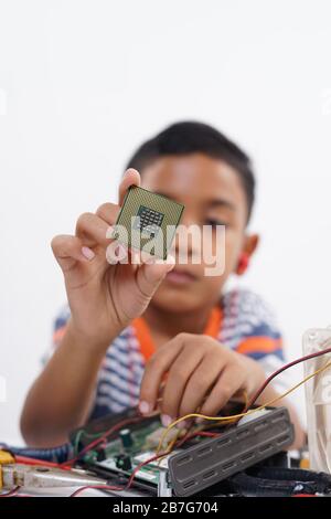 Boy holding processor for identify and repairing computer motherboard ...