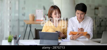 Close up view of two businesspeople sitting in glass partition and working together Stock Photo