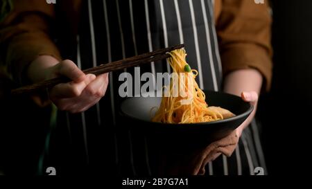 Close up view of a woman ready to eat Schezwan Noodles or Chow Mein Stock Photo