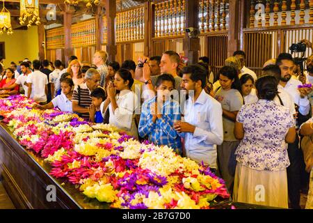 Sri Lanka Kandy Sinhala ancient capital Sri Dalada Maligawa Temple of the Sacred Tooth Relic Buddhist Buddhism interior floral offerings worshippers Stock Photo