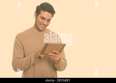 Young happy Persian man using digital tablet Stock Photo