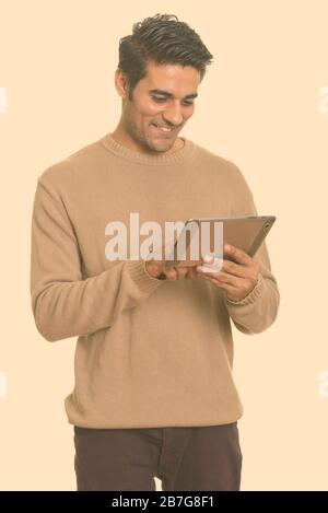Young happy Persian man using digital tablet Stock Photo