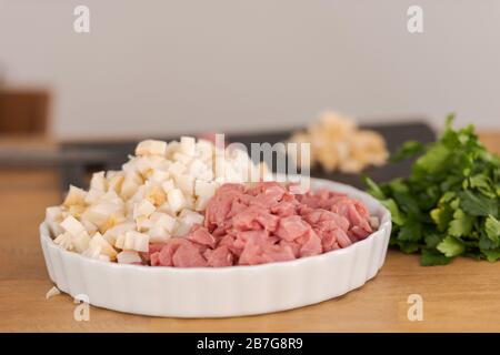 Making bavarian white sausages at home, lard and veal cut into cubes lying in white bowl Stock Photo