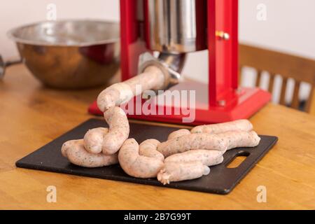 Making bavarian white sausages at home, chain of sausages lying on table Stock Photo