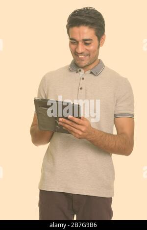 Young happy Persian man using digital tablet Stock Photo