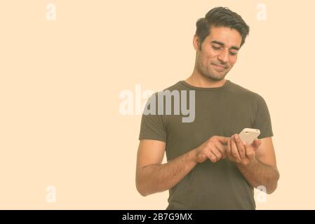 Young handsome Persian man using mobile phone Stock Photo