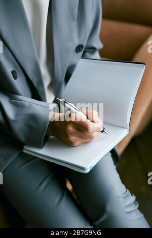 High angle close up of successful mature businesswoman writing in planner, copy space Stock Photo