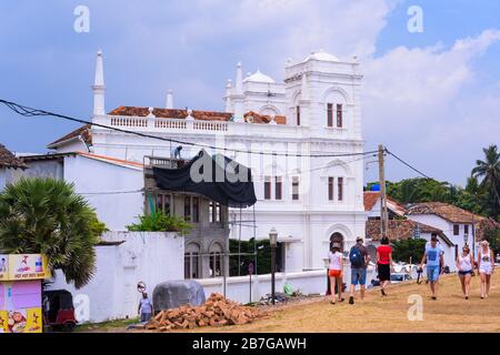 South Asia Sri Lanka Fort Galle colonial town centre old ancient harbour port white Meeran Mosque street scene houses people palm trees Stock Photo