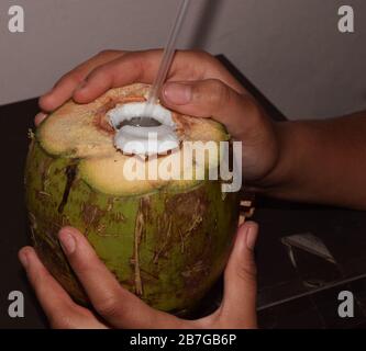 Fresh Tender Coconut drink with straw also called as Daav or Nariyal Pani in India Stock Photo