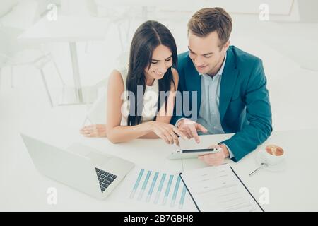 Two young business people working on new project. Man shows a woman the advantages of investing in his company Stock Photo