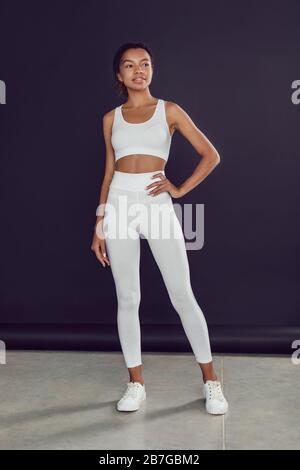 Young african american woman in white blank leggings and a crop top. Mock-up.