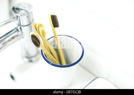 Bamboo wooden toothbrush in metal glass in bathroom interior. No plastic, zero waste, eco friendly concept. Stock Photo