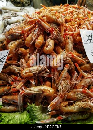 Freshly caught scampi with scissors are on sale at a market stand in Italy. Delicious seafood that is offered fresh for sale. Italian food market. Stock Photo