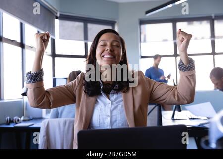 African American woman raising their hand in victory in office Stock Photo
