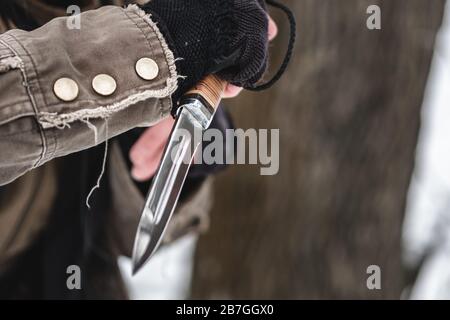 Military mercenary holds a steel knife in his hand. Close up. Stock Photo