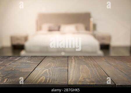 Empty wooden board and blurred modern bedroom with house interior as background for display your products. Abstract pattern. Stock Photo