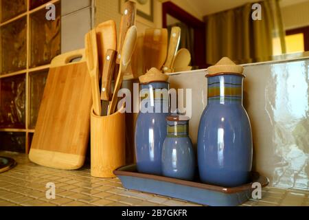 Seasoning bottles and wooden utensils on the kitchen counter Stock Photo
