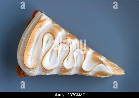 Slice of a Tasty Lemon Meringue Tart on Blue Grey Plate Stock Photo