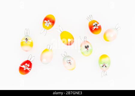 Colorful painted easter eggs with funny bunny ears and cartoon faces on white background Stock Photo