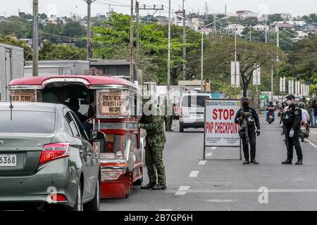 Quezon City. 16th Mar, 2020. Policemen from the Philippine National Police (PNP) inspect people at a checkpoint in Quezon City, the Philippines on March 16, 2020. Philippine President Rodrigo Duterte has placed the entire main Luzon island in the Philippines under 'enhanced community quarantine' in a drastic bid to contain the spread of the COVID-19 in the country, Presidential Spokesman Salvador Panelo said on Monday. The Philippines now has 140 confirmed COVID-19 cases, including 12 deaths. Credit: Rouelle Umali/Xinhua/Alamy Live News Stock Photo