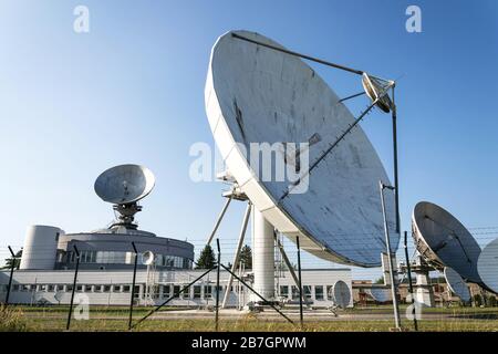 Barbed wire fence around satellite links center with telecommunication tower equipped with radar antennas, cybercrime and cybersecurity concept Stock Photo