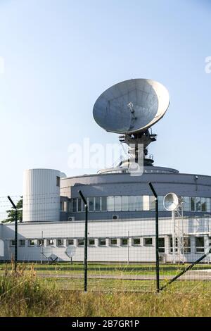 Barbed wire fence around satellite links center with telecommunication tower equipped with radar antennas, cybercrime and cybersecurity concept Stock Photo