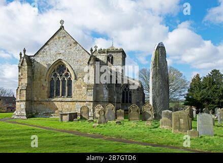 The Rudston monolith, the tallest standing stone in England, next to All Saints Church, in the village of Rudston, East Yorkshire, England UK Stock Photo