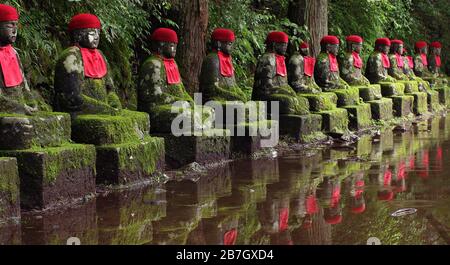 Aligned jizo buddhist statues in Nikko, Japan (Kanmangafuchi Abyss) Stock Photo