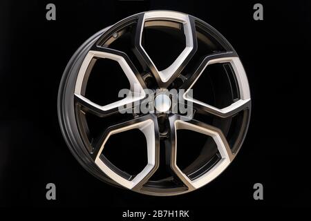 aluminum alloy wheel. Premium cast, the design of the spokes and the wheel rim, a white and black elements on dark background close-up. Stock Photo